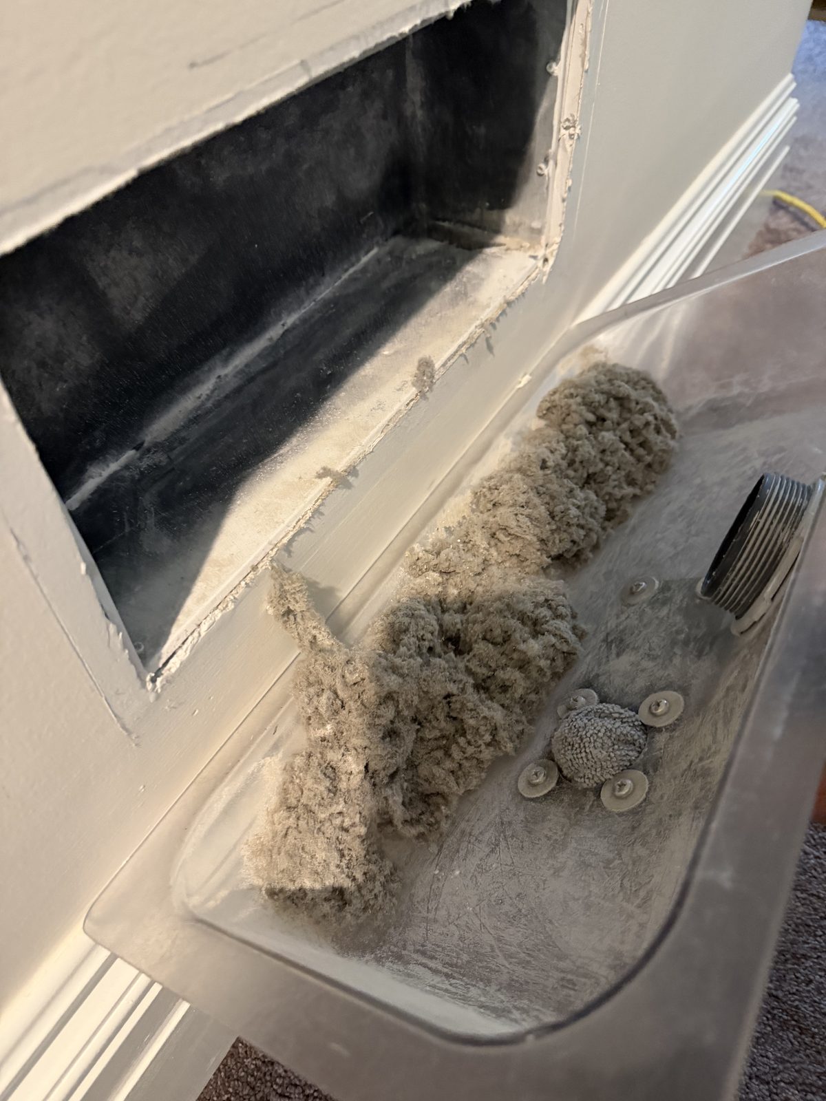 The catch tray after a return was brushed out, full of gray dust and lint