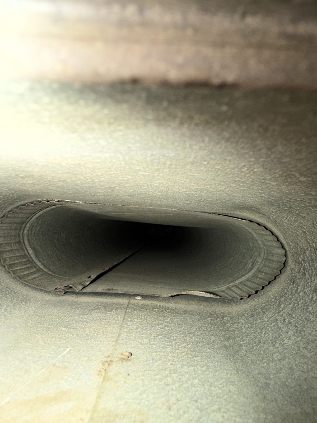 The same duct after cleaning, clean metal up to the opening