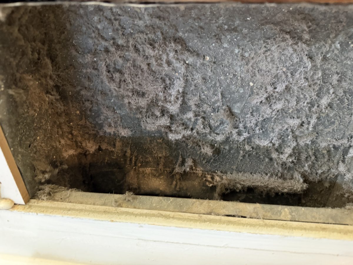 A register box furred with dust inside, before cleaning